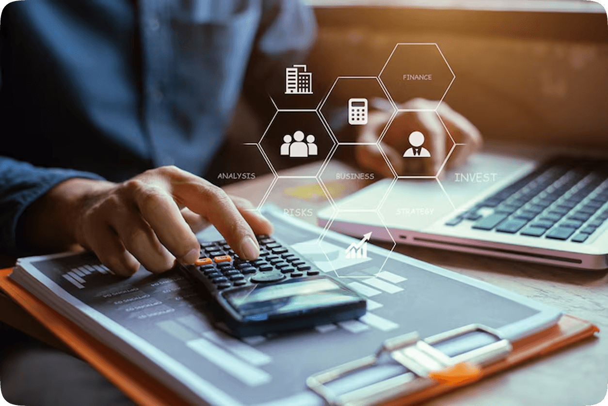 Person operating calculator over papers reflecting financial analytics UI
